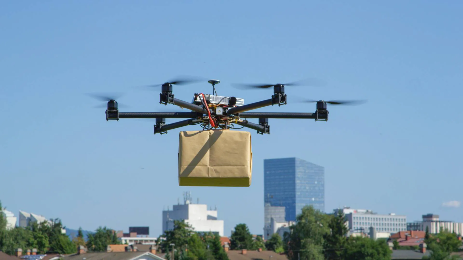 Autonomous delivery drone in flight over urban area